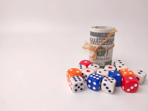 A rolled stack of United States dollar bills secured with twine sits next t.. 库存照片