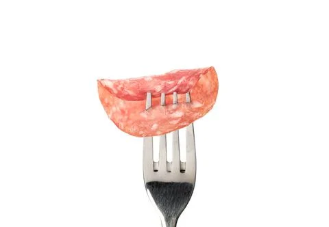 Rolled up thin slice of cooked smoked sausage on a fork. Foto stock