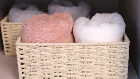 Rolled towel into wicker basket standing in the closet close-up. Stock Footage 235284669