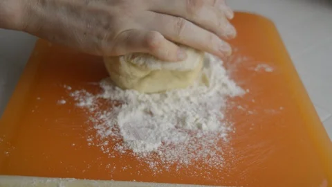 Rolled wheat dough and rolling pin on a table Stock Footage 129947736