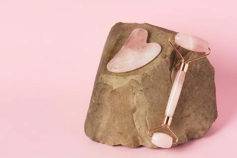 Roller and gua sha massage scraper on natural stone Stock Photos