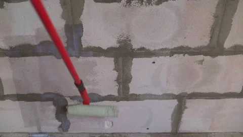 Roller application of waterproofing sealant to the wall. Applying a primer to a Stock Footage 149005899