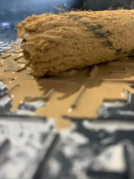 A roller in beige paint on a stand for rolling out paint Stock Photos