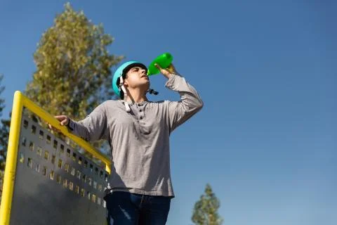 Roller boy drinking water in a bottle in a skate park Stock Photos