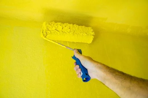 Roller Brush Painting, Worker on surface wall, renovating with yellow color Stock Photos