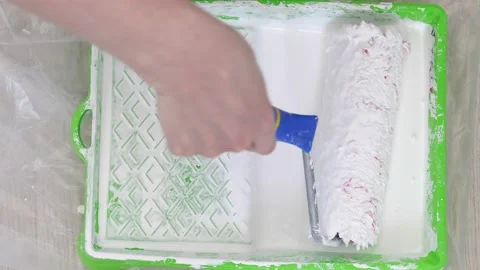 Roller brush purified from the excess of white paint. Video stock 130707580