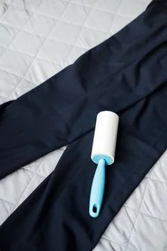 Roller for cleaning clothes from dust and pellets on dark trousers, top view Stock Photos