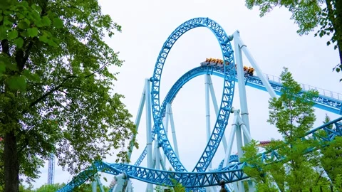 Roller coaster cart with people riding on it goes through an upside Stock Footage 295945142