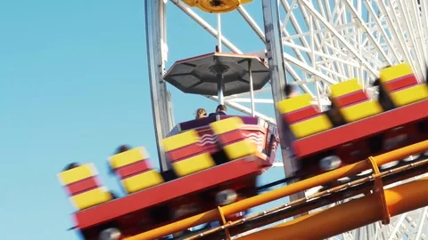 Roller Coaster Passing in Front of Ferris Wheel Stock Footage 74304270
