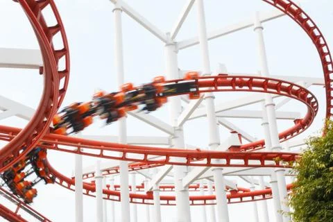 Roller coaster rail loop with motion blur player over cloudy sky Foto stock