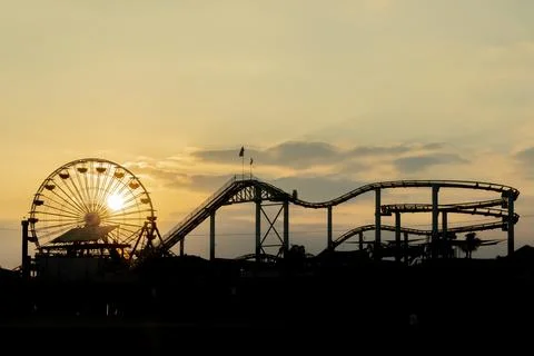 Roller Coaster Silhouette Glows at Sunset Along California Coast Stock Photos