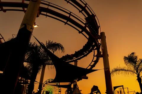 Roller Coaster Silhouette Glows at Sunset Along California Coast Stock Photos