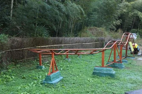 The roller coaster track is located in the bamboo forest, with green grass .. Stock Photos