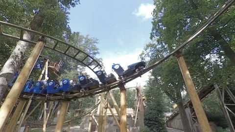 Roller coaster tracking shot at fairground in forest Stock Footage 118255462