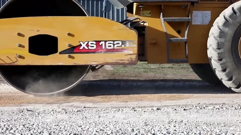 The roller compacts the gravel, preparing the ground for the road. Repair of Stock Footage 205088714