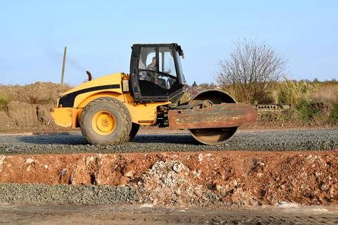 The roller compacts the rubble on the road. Stock Photos