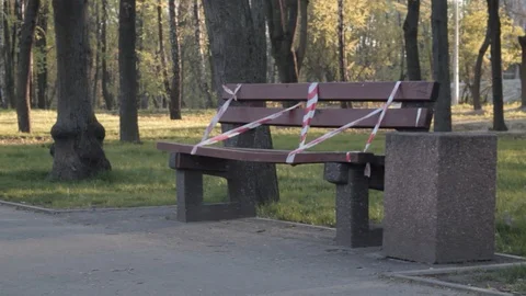 Roller girl crossing empty bench covered with restrictive tape in park Stock Footage 129240572