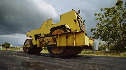 The roller levels and compacts the asphalt. Construction machinery makes a road. Stock Footage 137868344