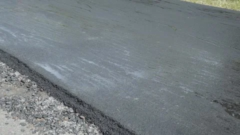 The roller levels and compacts the asphalt. Construction machinery makes a road. Stock Footage 137868349