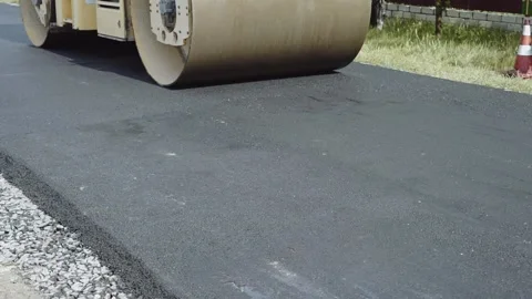 The roller levels and compacts the asphalt. Construction machinery makes a road. Stock-Footage 137868351