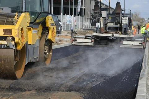 Roller machine compressing the asphalt behind the paver Foto stock