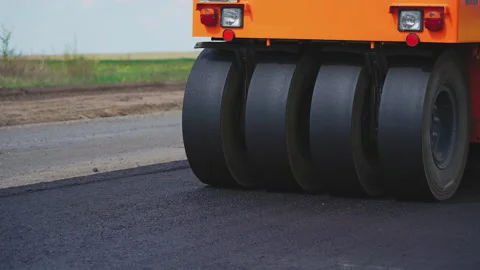Roller machines make new asphalt roads. The asphalt paver squeezes hot asphalt. Stock Footage 130194769