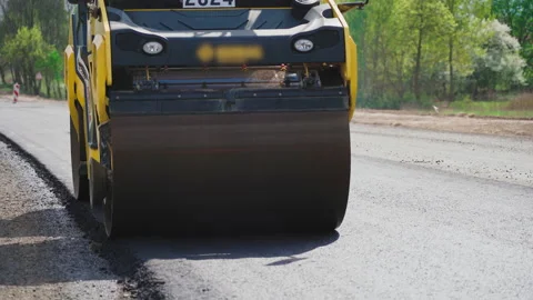Roller machines make new asphalt roads. The asphalt paver squeezes hot asphalt. Stock Footage 130195224