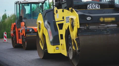 Roller machines make new asphalt roads. The asphalt paver squeezes hot asphalt. Stock Footage 130196852