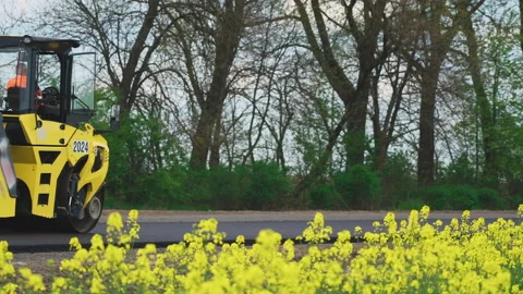 Roller machines make new asphalt roads. The asphalt paver squeezes hot asphalt. Stock Footage 130197299