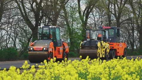 Roller machines make new asphalt roads. The asphalt paver squeezes hot asphalt. Stock Footage 130197380