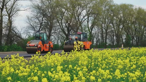 Roller machines make new asphalt roads. The asphalt paver squeezes hot asphalt. Stock Footage 130197630