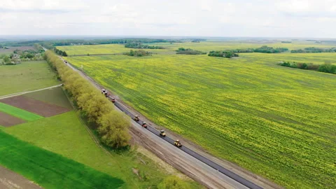 Roller machines make new asphalt roads. The asphalt paver squeezes hot asphalt. Stock Footage 130198285