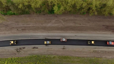 Roller machines make new asphalt roads. The asphalt paver squeezes hot asphalt. Stock Footage 130198585