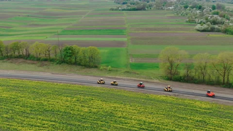 Roller machines make new asphalt roads. The asphalt paver squeezes hot asphalt. Stock Footage 130199005