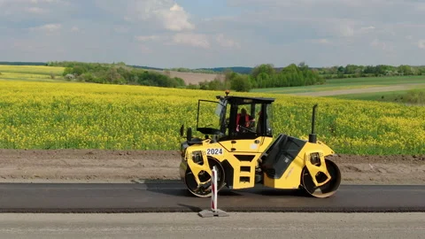 Roller machines make new asphalt roads. The asphalt paver squeezes hot asphalt. Stock Footage 130199661