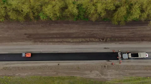 Roller machines make new asphalt roads. The asphalt paver squeezes hot asphalt. Stock Footage 130201687