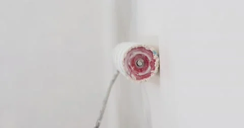 Roller painting white wall with white paint in the frame and leaves the frame Stock Footage 133282991