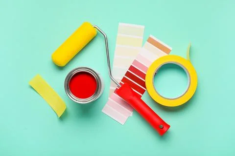 Roller with palette samples, can of paint and adhesive tape roll on turquoise Stock-Fotos