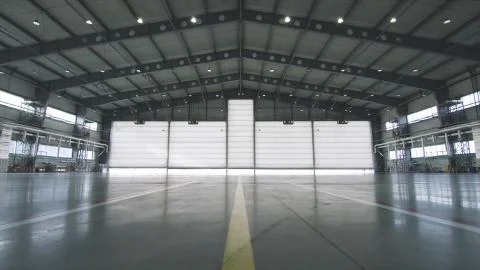 Roller shutter door and concrete floor inside factory building for industrial Stock Photos