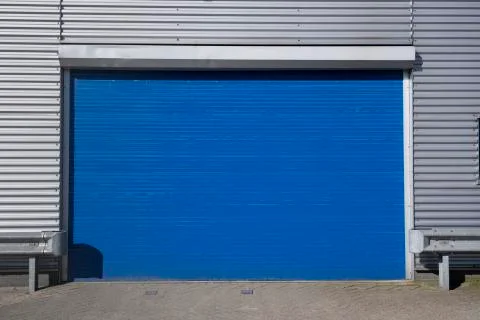 Roller shutter door and concrete floor outside factory building Stock Photos
