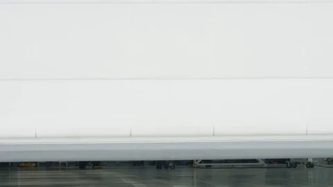 Roller shutter door and plane in hangar background. Business jet airplane is in Stock Footage 82438529