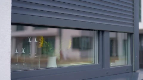 Roller shutter moves upward, revealing sunflowers and glass bottles inside 스톡 동영상 340650191