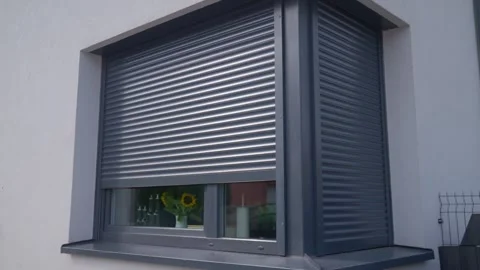 Roller shutter rises over house window, revealing more of the glass below 스톡 동영상 340918553
