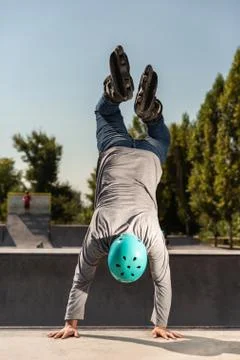 A roller skater does a trick on a ramp at a skate park Stock Photos