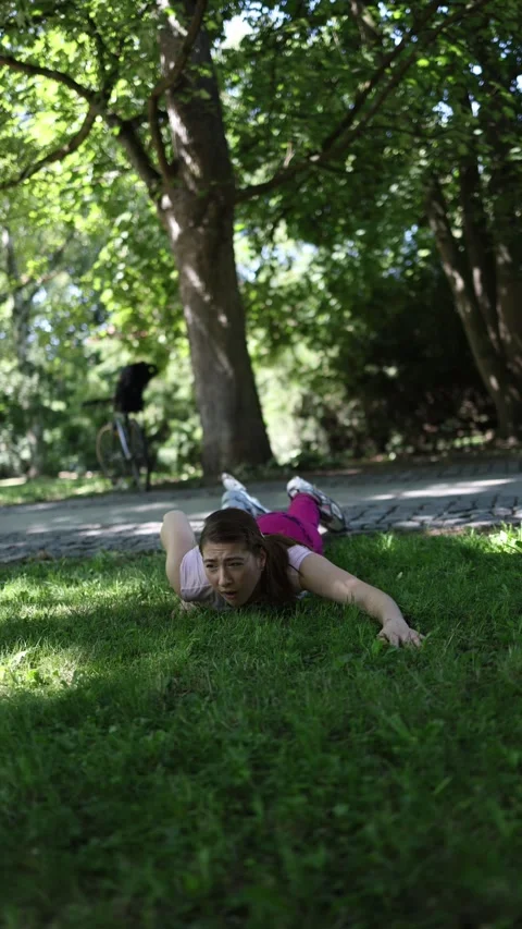 Roller skater falls onto grass after losing balance during a risky trick Video stock 341476666