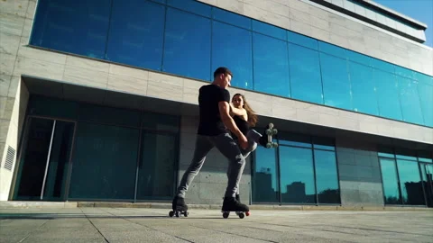 Roller skaters doing acrobatic tricks in front of building Stock-Footage 141188431