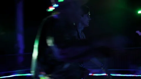 Roller skaters in an electronic disco music atmosphere with colored lighting Stock Footage 121710796
