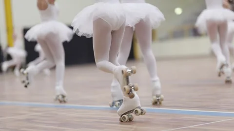 Roller skaters performing a ballet routine in white tutus Vídeos de archivo 324761314