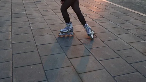 Roller skates circle the sidewalk illuminated by the rays of the orange sunset. Stock Footage 119315459