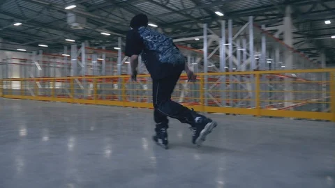 Roller skating guy does the trick at the logistic center in slowmotion and falls Video stock 104361739